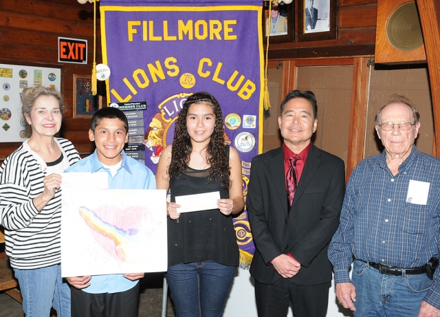 Aries Vega (holding poster), Fillmore Middle School student, has taken the first step to becoming a state wide recognized artist by winning the local competition sponsored by the Fillmore Lions Club. This year’s theme was “Imagine Peace”. Aries’ work was selected from the work of students in Doris Nichols’ (far left) art classes. Aries’ poster has been forwarded to the local Lions District for further competition in California. When Aries was asked how his poster represented the theme he responded, “Peace is what you do and see in the world and what to expect from it”. The runner-ups were Leonardo Rodriquez and Markayla Aguilar (holding certificate). Aries received $50 as the winner and Leonardo and Markayla $25. Judges Todd DeMheen and Ken Mittan (far right) were impressed by the many fine posters submitted. They also want to encourage all students to participate again next year. Also pictured Fillmore Middle School Principal Gary Mayeda.