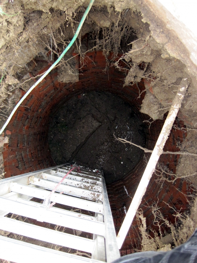 The abandoned cesspool located in the unidentified man's backyard.