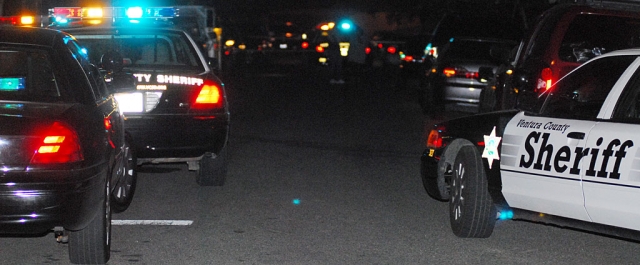 Above, police cars block the entrance to Bard Street while investigating a homicide committed Saturday night, July 17th.