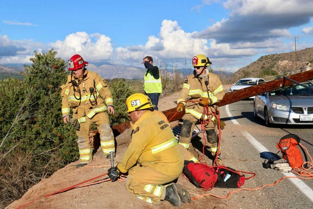 Friday October 28th, approximately 3:30 p.m., Fillmore Fire Department was requested to assist Santa Paula Fire Department on South Mountain Road to reports of a vehicle over the side. Upon their arrival their findings were two power poles with live wires on the ground with one of the power poles resting on one vehicle and trapping two others between the poles. Upon further investigation a small SUV was found over the side of the road about 25 feet down the embankment, coming to rest on the River Bottom with one female and two dogs trapped inside the vehicle. Fillmore Fire and Santa Paula Fire were able to extricate the female driver, she was transported to Santa Paula hospital for evaluation and investigation was taken over by California Highway Patrol. Photos by Sebastian Ramierz