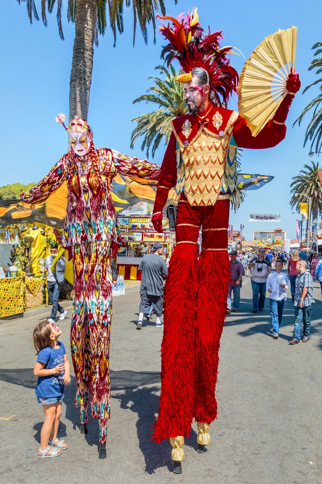 Photo of the Week "Little girl looking up to really tall people" By Bob Crum. Photo data: Canon 7DMKII camera, ISO 160, Tamron 16-300mm lens @16mm, aperture f/ll, shutter speed 1/250 of a second.