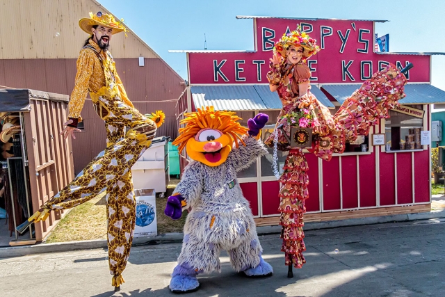 Photo of the Week "My favorite stilt couple at the Ventura County Fair" by Bob Crum. Photo data: Canon 7DMKII camera, manual mode, Tamron 16-300mm lens @16mm. Exposure; ISO 1600, aperture f/13, 1/640th second shutter speed.