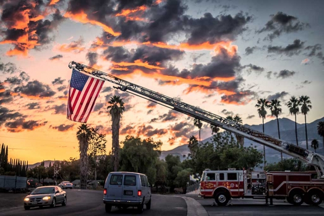 Photo of the week is "Fire Department 9/11 flag over Landeros Lane" by Bob Crum. Photo details: ISO 100, 22mm, f/5.0 @1/60second. 