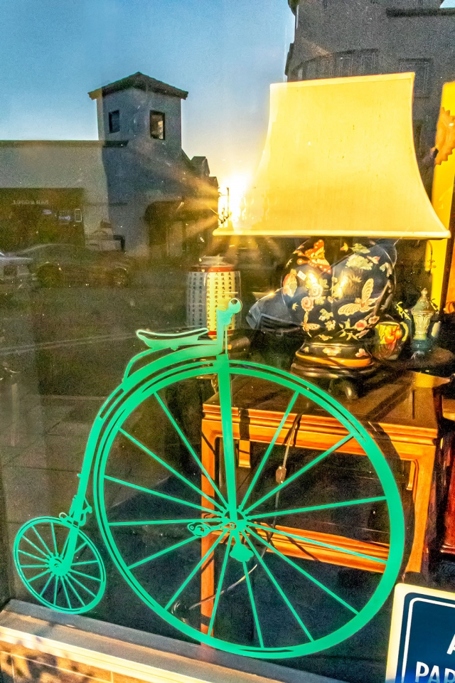 Photo of the Week: "Sun reflection on green unicycle in Central Avenue shop window" by Bob Crum. Photo data: Canon 7D MKII camera, manual mode with Tamron 16-300mm lens @16mm. Exposure; ISO 16000, aperture f/22, 1/500th second shutter speed.