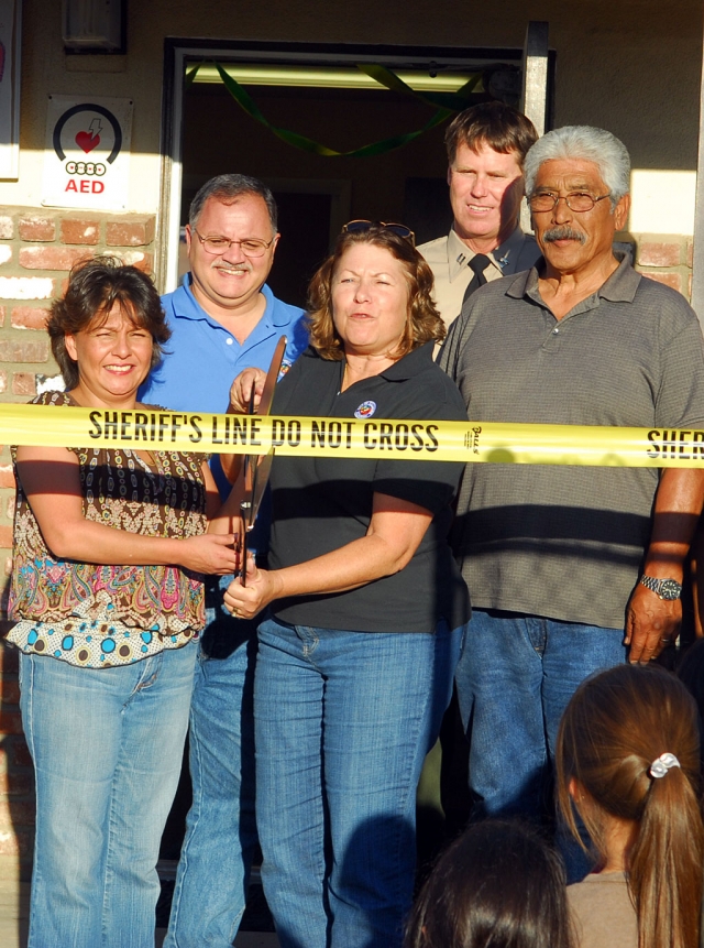 From left, Council members Lauri Hernandez and Jamey Brooks assist Mayor Patti Walker, Police Chief Tim Hagel and Retired Deputy Max Pena with ribbon cutting at rededication of the North Fillmore Police Sub Station.