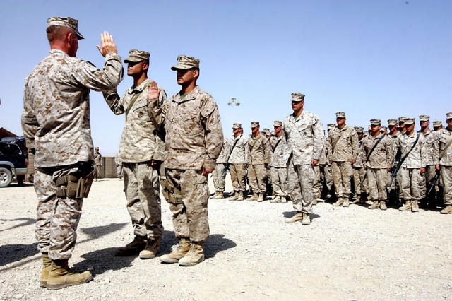 Lieutenant Gen. Samuel T. Helland, Commander of Marine Corps Forces Central Command, administers the oath of enlistment to Cpls. Ray Alvarado-Ponce of Fillmore, Calif., and Ramiro Novoa of Coachella, Calif., who were combat meritoriously promoted to their current ranks at Camp Barber, Aug. 31. (Official U.S. Marine Corps photo by Cpl. Ray Lewis)
