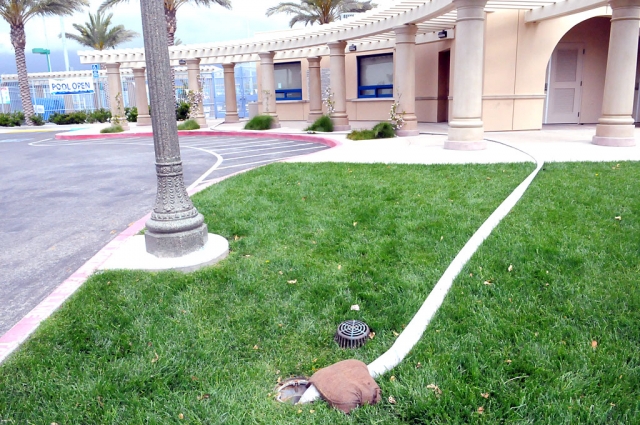 The “Pool Open” sign still hangs on the fencing at the Center. The drainage hose is shown in the foreground. The pool has been leaking 10,000 gallons of water per day for the better part of a year, unnoticed. See ‘Realities’ column in Editorial section more information.