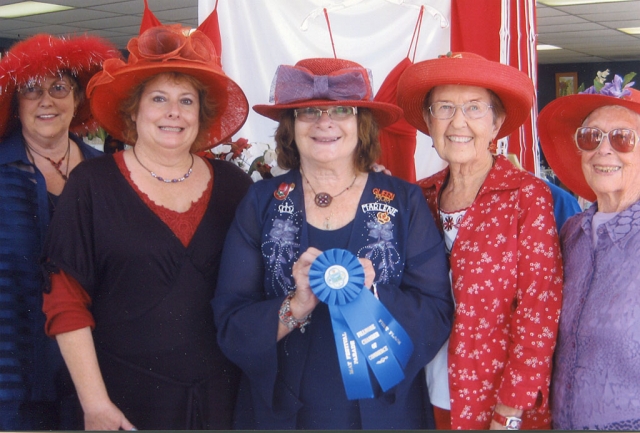 The Heritage Valley Red Hatters proudly display the first prize blue ribbon in the Fillmore May Festival Parade given by the Fillmore Chamber of Commerce. Ventura Motor Sports Car Club provided the beautiful classic cars and generous drivers of its president, Don Green, vice president, Bill Erickson, and Maria Lopez. Displaying the first place ribbon, from left to right, is vice queen, Beth Steele, co-queen, Sally Knight, Queen, Marlene Wait, Shirley Hargarten, and Katherene Plasch. Also in the parade were vice queen, Melodic Stich, Kate O’Brien, Vivian Johnson and Marcy Spade.
