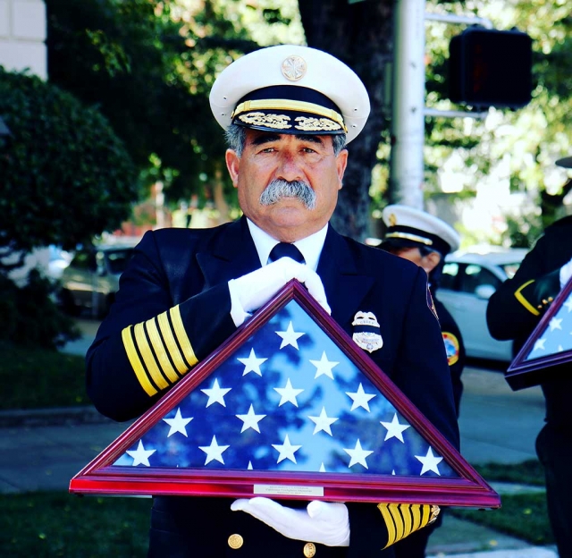 Fillmore Fire Chief Keith Gurrola holds the memorial flag for inductee Rigo Landeros at the Sacramento Firefighters Memorial Ceremony. The flag was presented to the Landeros Family and his name was etched in the memorial wall. 