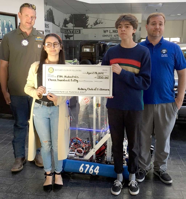 Rotary President Elect, Andy Klittich on the far left presented a check for $350 to the Fillmore High School Robotics Team. Two of the Robotics Team members, Paulina Guerrero and Andres Romero, holding the check, demonstrated the robot the team built. Their teacher, Mr. McMahon on the far right explained to the club about competitions they have participated in this past year. Photo courtesy Martha Richardson.