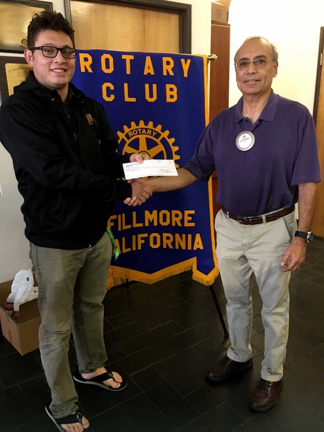 Jacob Brooks, Vice President of FHS Band Boosters Club, accepted a check from Rotarian Joe Aguirre, chairman of 5/10K Run. This donation came from Santa Clarita Runners Club who enjoys giving back to Fillmore youth. 