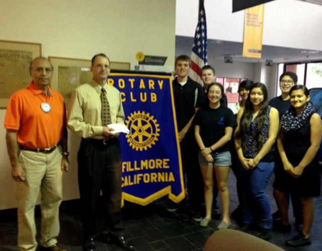 Last week Rotarian Joe Aguirre presented a check, for $300 to Kevin McSweeney, for the 5/10K Run. Kevin was representing the Santa Clarita Runners Club also known as the Bandits. He in turn donated the money to the Fillmore High School Band. The Rotary Club also presented the band with $500. Pictured, Joe Aguirre, Kevin McSweeney and several members of the FHS band.