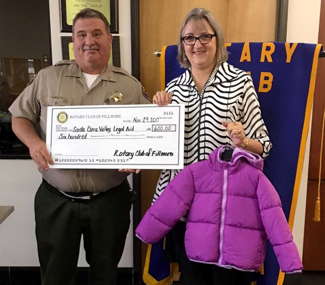 Police Chief Dave Wareham of the Fillmore Lions Club presented Laura Bartels, of Santa Clara Valley Legal Aid with a check for $600 toward the purchase of new coats. The coats will be given out at the Community Christmas Giveaway on Dec. 16. Donations are still needed, call 524-1934 for more information.