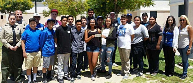 Isela Larin (left) and Lidia Arredondo (far right) from the Fillmore Citizen Patrol, present a donation of $1,000 to the newly formed Fillmore Middle School Public Safety Club.