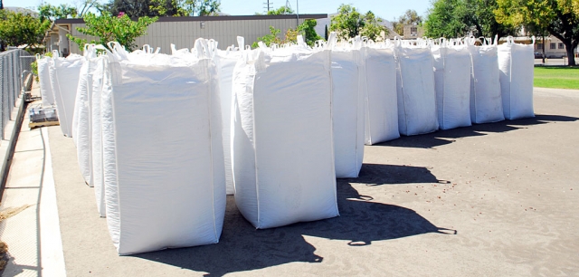 Truckloads of rubberized mulch made their way into Fillmore last week to replace the aged woodchips at the district’s elementary school playgrounds. Sespe, Piru, and San Cayetano will all benefit from the recyclable rubber, made from 45,000 old tires, shown in packages stored at the district. A grant of $144,000 provided for the mulch, according to Denise Berrington, facilities secretary at the Fillmore Unified School District. Piru Elementary’s chips have already been replaced with blue rubberized mulch, and Sespe and San Cayetano are next, opting for the more natural looking cypress red shade. The mulch provides maximum fall protection for students on the playground.