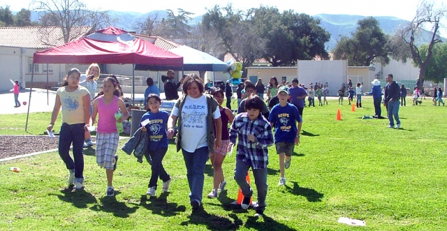 Sespe School Secretary Amelia Ramirez walking with some students.