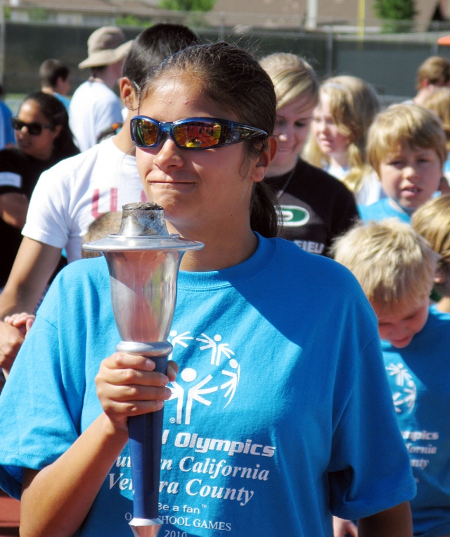 Congratulations! Stacia Helmer coached the Special Education students at Fillmore High School in the Ventura County Special Olympics at Nordoff High School, Ojai on May 22. Pictured is Anna Maldonado who was chosen to carry the Olympic torch. The students competed against other Ventura County School Districts in the track and field events. The events included the Tennis Ball Drop, Softball Throw, Standing Long Jump, 25M Assisted Walk, 25M Race, 30M Motorized Wheelchair Slalom, and the 100M Race. Each of the following athletes went home with 2 metals: Anna Maldonado, Jacob Gaither, Jamie Rhett, David Hynes, Lorena Perez, Jessica Ramirez, Leo Magana, Gisela Martin, Kislev Valenzuela and Jose Hernendez.