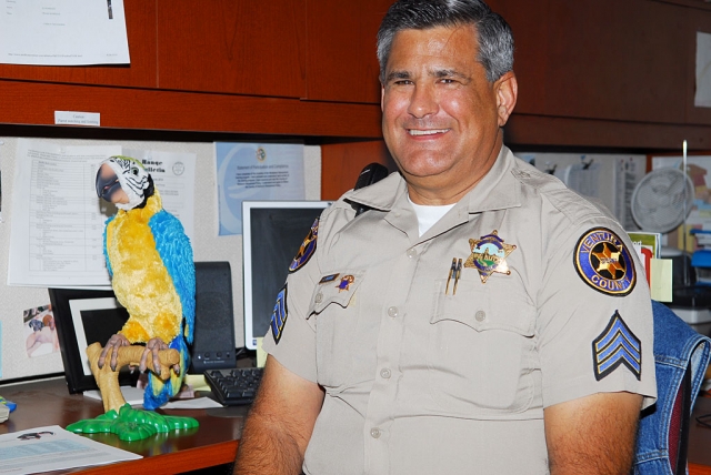 Sgt. Jim Aguirre shares a desk with his stuffed parrot. The bird talks, squawks and flaps its colorful wings. Bird seed is optional.