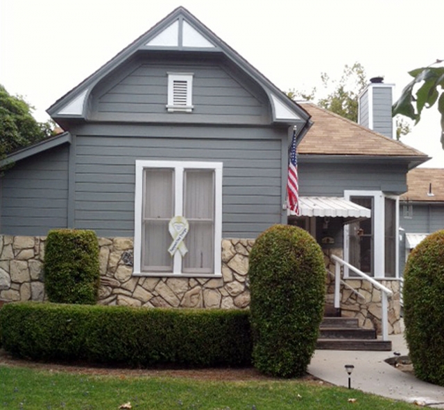 A home displaying the United States Flag and a large Support Our Troops Ribbon.
