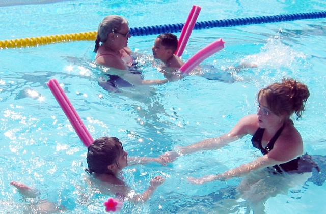 Cindy Blatt (left) and Andie McDonnell, instructor/lifeguard, are pictured with several swimmers, learning to swim. Two week sessions meet five days per week. Instruction Levels 1-6 are regularly scheduled. Group lessons are $50 per session. Private Lessons are $100 per session. Sign-up at pool M-F 5:45-7:00PM and Saturday 1-4PM.