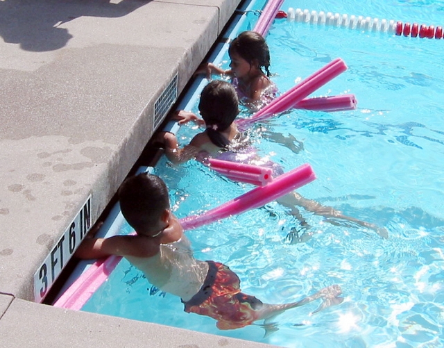 Three children learn to swim at Fillmore’s community pool.