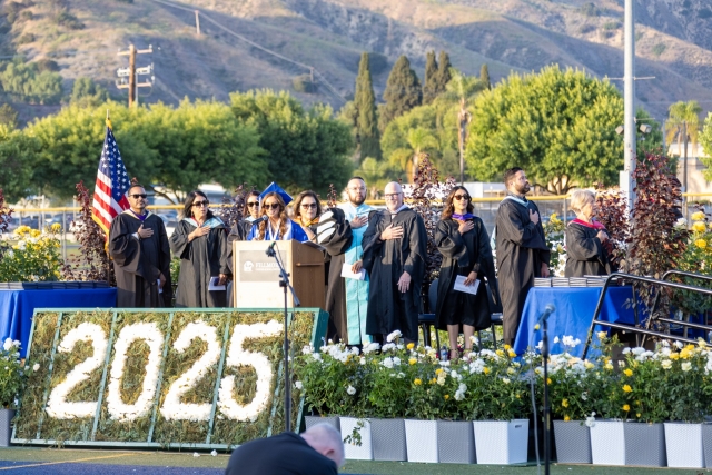 On Thursday, June 5th, Fillmore High School held its 2025 Graduation Ceremony at 7pm. The event began with students riding on buses to the football stadium, where they walked across the stage to receive their diplomas. Above is the beginning of the ceremony with all standing for the National Anthem/Pledge of Allegiance. Inset, Fillmore High School Class of 2025 celebrating by throwing streamers in the air. 