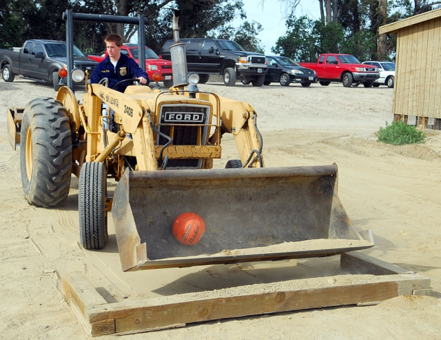 Among the various events at Saturday’s School Farm was a demonstration of skill with a front loader. Here Travis Doop from Carpinteria must pick up a basketball from a pit and re-place it without dropping or
damaging it. Doop placed first in this competition. Fillmore Ag Boosters provided all the trophies, ribbons
and food.