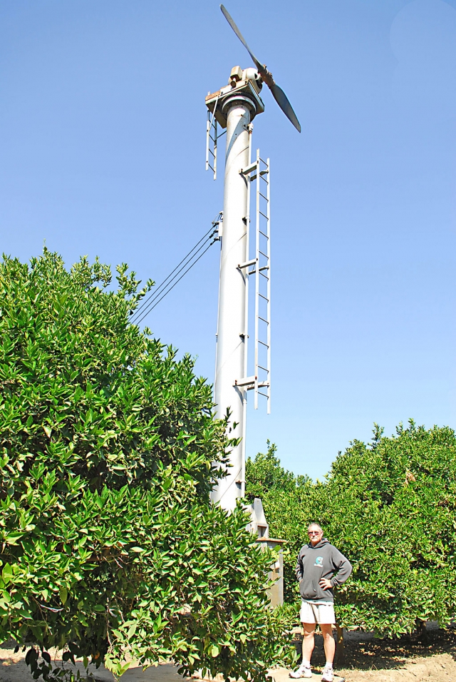 Fillmore Pastor-Farmer Bob Hammond poses before the wind machine he is attempting to convert to electric generation. He has had very little assistance from the numerous government agencies through which he seeks approval.