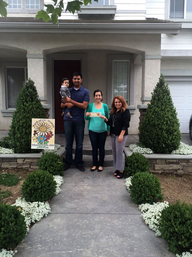 Theresa Robledo with Civic Pride Vision 2020 presents Yard of the Month to Freddy, Cynthia & their precious baby Isaac! Congratulations!  Please drive by 760 River Street to view their lovely yard!  Their home is located on River Street & Surrey, where you will see Boxwood, Star Jasmine, Roses, Ferns, and beautiful stamped concrete walkway and driveway.  Their home is located in the Riverwalk Tract where you will find nice walking paths along the river!  Thank you to Otto & Sons Nursery for their generous gift certificate, where they will find more items for their yard!