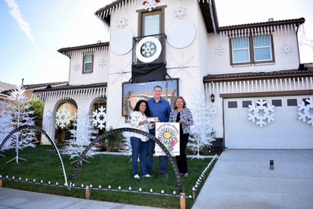 Ari Larson from Fillmore Civic Pride (right) presenting Rosa and Ron Howard with a $40 gift certificate to Otto & Sons Nursery, for being the 2017 December Yard of the Month.