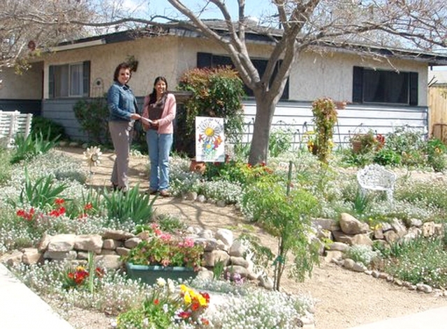 Vision 2020 Civic Pride committee member Linda Nunes presents “Yard of the Month” award to Kathy Pace.
