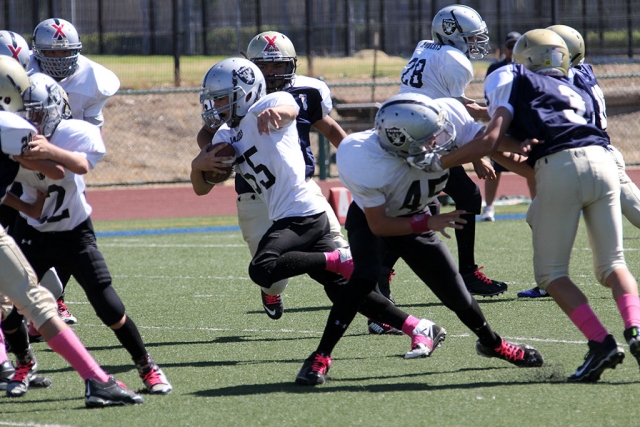 Raiders junior 2 #22 and #45 make the way for #55 to run for a fist down