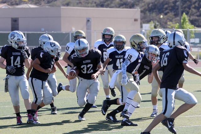 Raiders J1 #32 runs for a first down while picking up some blocks along the way