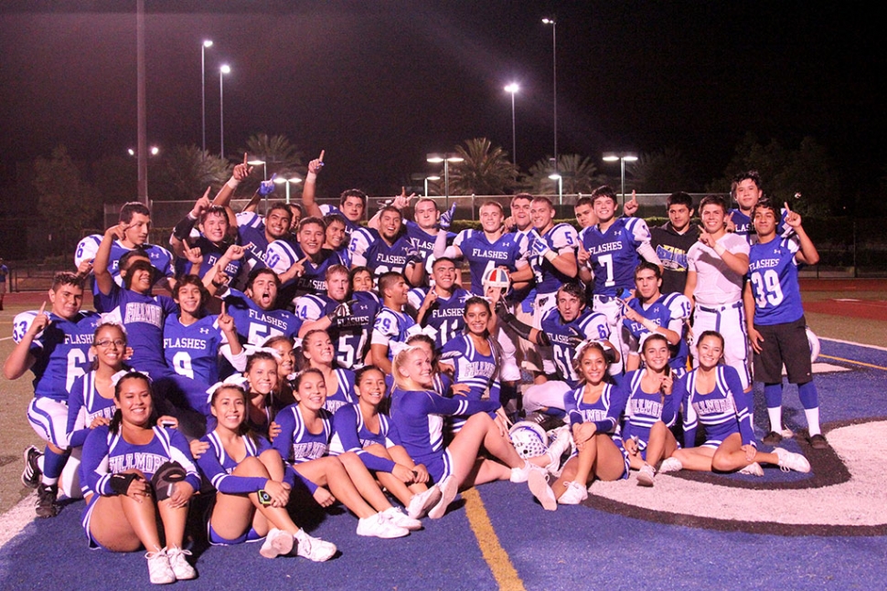 Football team and Cheer Leaders Pose with helmet after exciting win