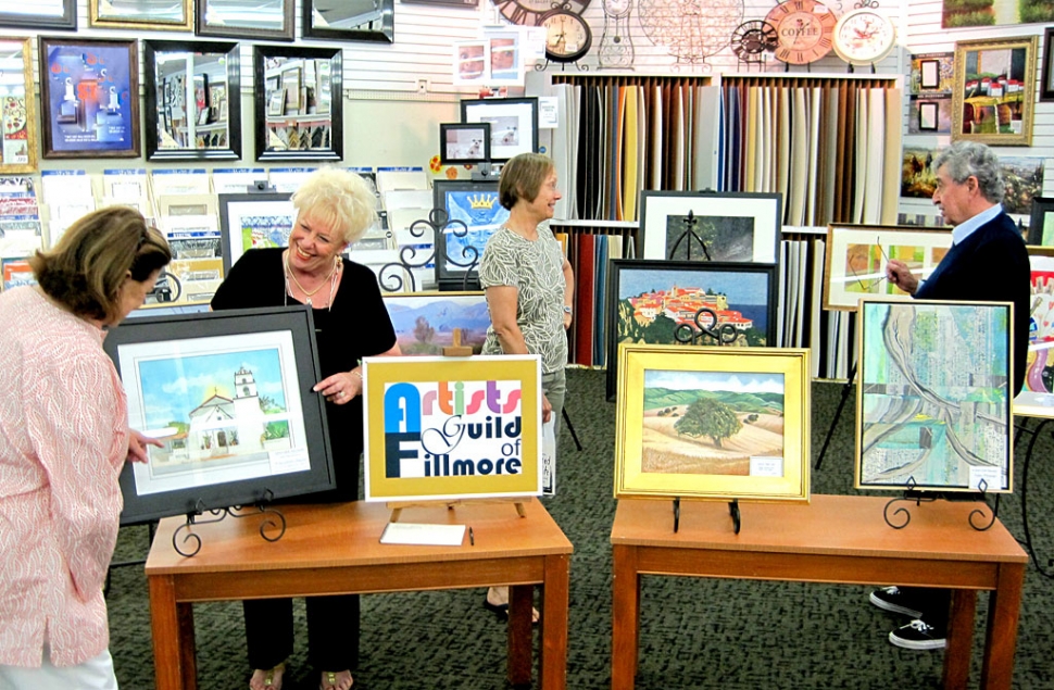 Luanne Perez and Jan Faulkner (both in center) are discussing the art works by the Artists Guild of Fillmore with interested Susan and Gil Rosas of Santa Barbara.