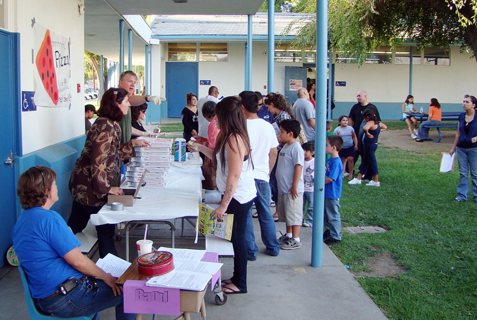 Back To School Night at San Cayetano was very busy in addition to classroom visits. Shown here are Mrs. Resor, the Elementary Band teacher looking for new recruits and Mrs. Overton and Mr. Meich are selling pizzas to raise money for additional classroom materials.