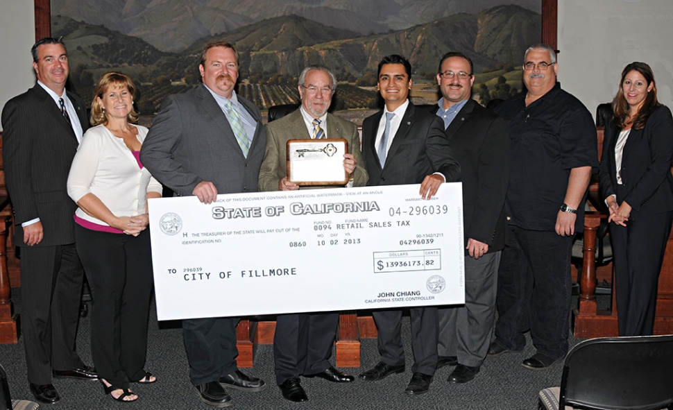 From the left: City Manager David Rowlands, Councilmember Diane McCall, Mayor Rick Neal, Mike Sedell, Mayor Pro-tem Manuel Minjares, Councilmembers Douglas Tucker and Steve Conaway, and City Attorney Tiffany Israel. This is a day for the residents of Fillmore to rejoice and remember. The $14 million dollar check presented at Tuesday’s regular council meeting represents a strong new start for the City of Fillmore. It’s been a long time coming. The team shown in the photo above, and our hard-working city staff, are responsible for this financial victory. Special thanks is also due to Mike Sedell, former City Manager of Simi Valley. He has used his unique, extensive experience with tireless voluntary efforts to get Fillmore back on track at many levels. No one deserves the key to the city more than Mike Sedell. Congratulations to the whole team.