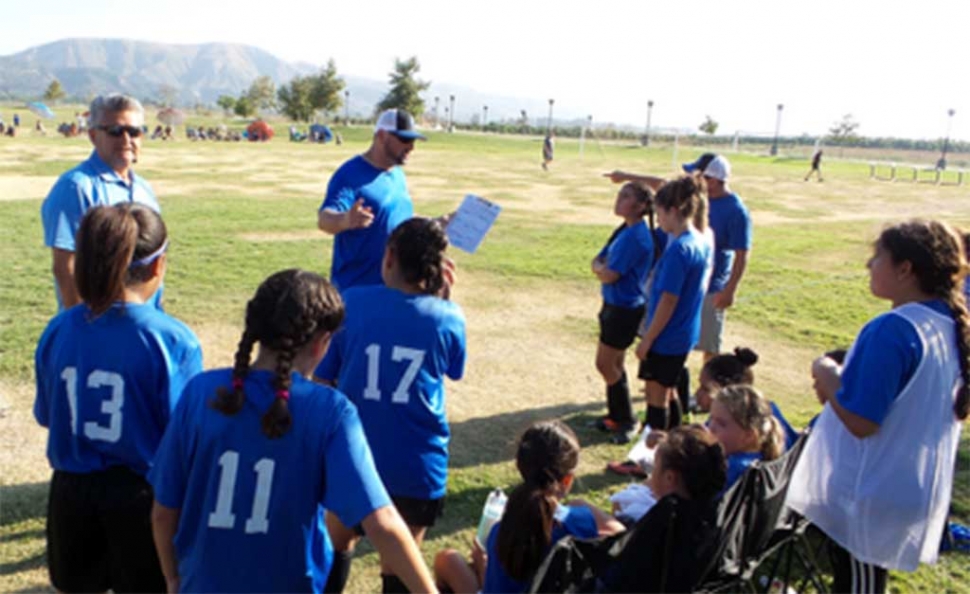 California United U-11 Coaches going over the adjustments the team needs to make before they begin the second half of the game against Valley United. Photo Courtesy of Ofelia Tello.