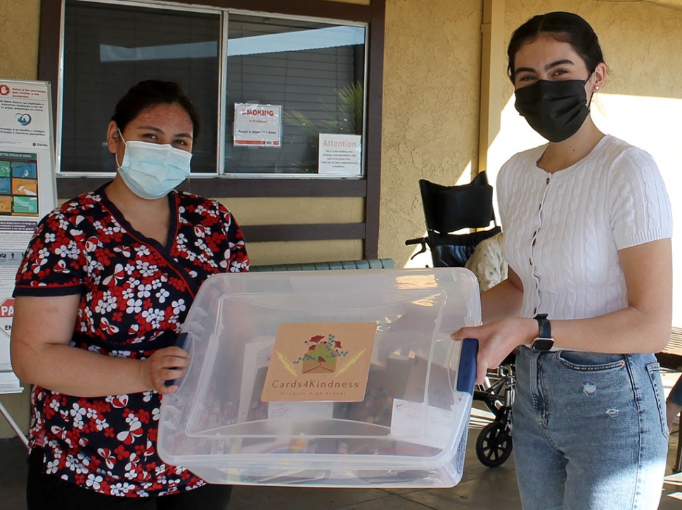 (left) A Greenfield Care worker receiving the cards from Club President Emilia Magdaleno on behalf of Flashes Cards for Kindness Club.