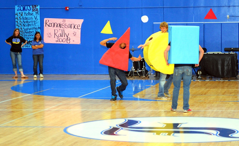 They were dancing in the streets, actually the high school gym, at the Renaissance Rally 2008, Friday. The theme of the day was “Shape Up for API”, and several students, including Colin Cone as the circle, were doing the “shape” dance, as teachers (left) Darby Schieferle and Cinda Francis look on.