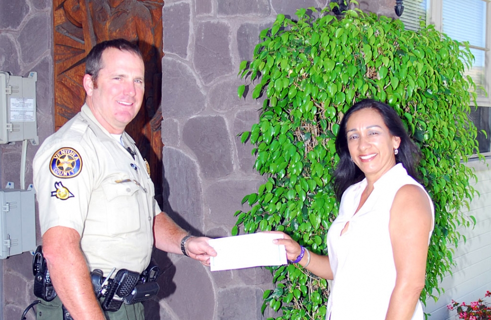 Annette Fox accepts a check in the amount of $200 from Deputy Biter who represented the Sheriffs Association.