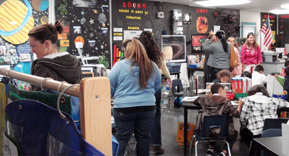 Piru visitors tour the primary grade science lab at Fenton Charter School, while Fenton students are working cooperatively on a project about ecosystems.