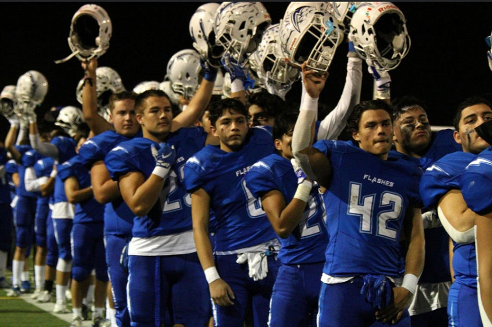 The Flashes raising their helmets for the national anthem before a home playoff game against Coachella Valley. Photo Courtesy Crystal Gurrola.