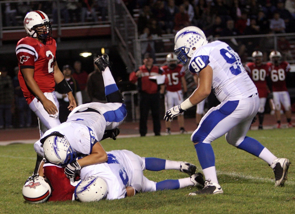 Emilio Gomez #90 helps out with the tackle.