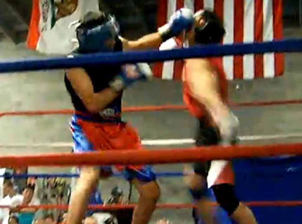 Jonathan Minero, wearing the black jersey and blue gloves, lands a left jab.