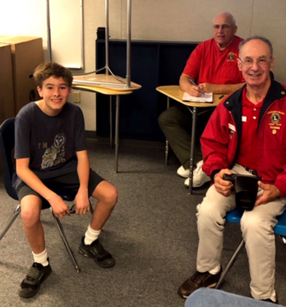 Pictured is Fillmore Middle School eighth grade student Cody Spore ready for his vision screening, while members of the Lions Club look on.