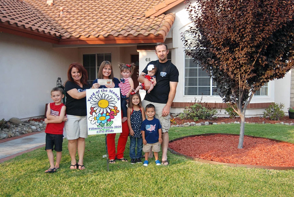 Theresa Robledo presents Fillmore Vision 2020 Civic Pride’s Yard of the Month for July to Jairus and Sarah Rothermel and their lovely extended family!  Congratulations! Their yard is located at the corner of Mockingbird Lane, you will find beautifully manicured greens, succulents, pansies, cactus, aloe vera, and cherry tree.  Jairus and Sarah moved back to Fillmore a couple of years ago from Northern California!   They make a beautiful addition to our community!  A Big Thank you to Otto & Sons Nursery for providing a gift certificate to the winners, where they will find more of their gardening and plant needs!