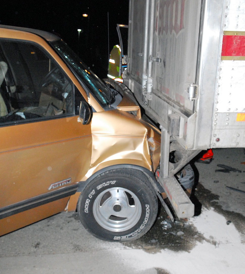 A van driven by a single male crashed into the rear of an 18-wheeler parked at the curb in the westbound lane. The driver was transported to hospital with undetermined injuries.