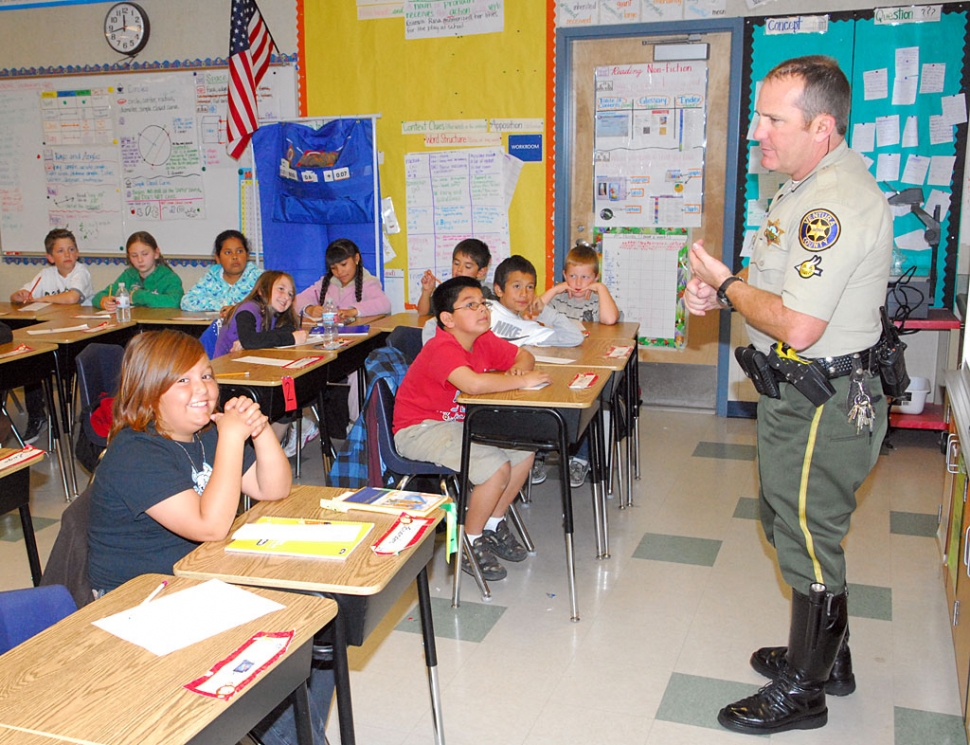 Motorcycle Deputy Tony Biter talks to the children at Mountain Vista School on Wednesday March 11, as part of the Adopt a Cop program.