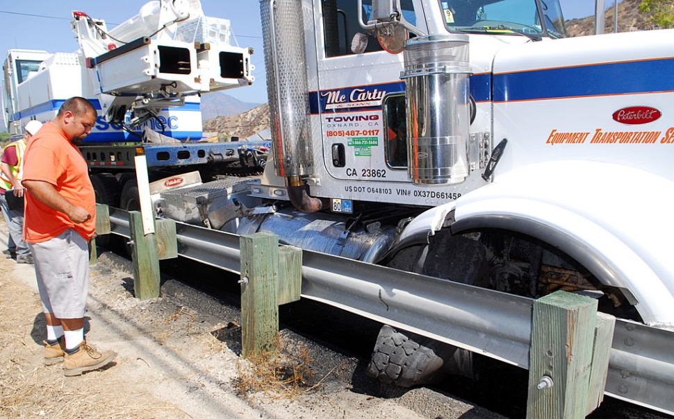 Monday morning, at approximately 10am, a Mc Carty & Sons Towing (Oxnard) big rig blew a tire on Highway 126 in front of the El Dorado Mobile Estates Park. An eyewitness said the tire exploded and hit the gas tank, rupturing it. About 100 gallons of diesel fuel spilled. The driver was able to bring the truck to a safe stop after hitting the guardrail. Fillmore Fire, CalTrans and Officer Biter, pictured, were on scene to coordinate the clean-up. No injuries occurred.